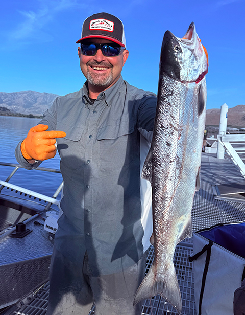 Austin Moser holding a large sockeye salmon during an action-packed opening day at Brewster Pool.