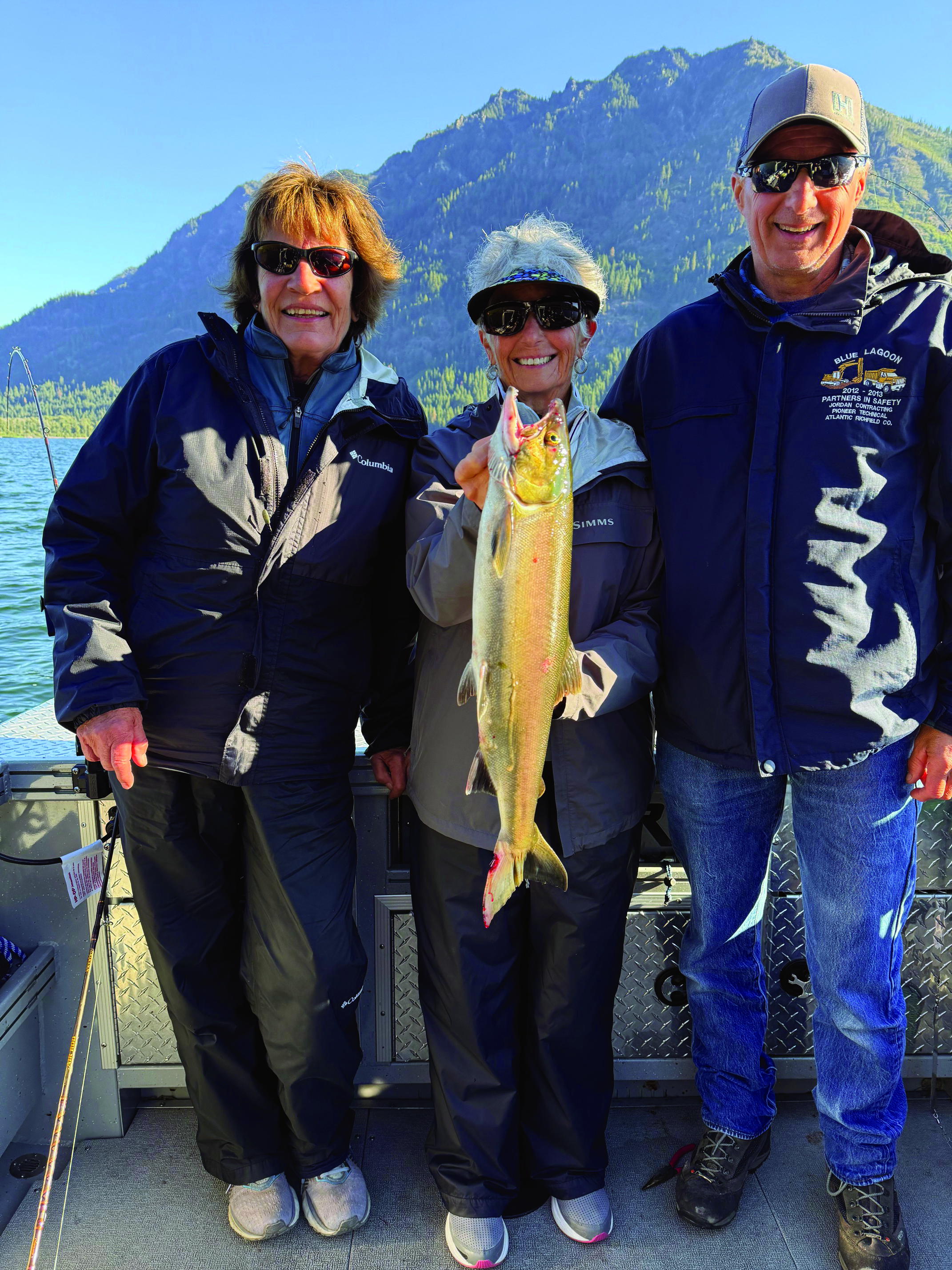 Janet Pace holding a Lake Wenatchee sockeye, joined by Ed and Karen Heim, during a rain-soaked but rewarding morning on the water.