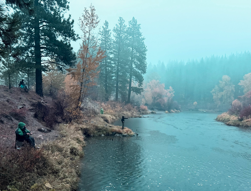 Anglers line the shores of the Icicle River on a rainy opening day of the 2025 coho season.